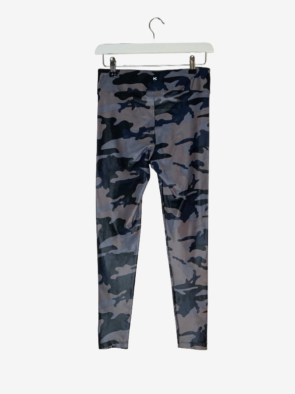 Slim-fit leggings with a dark gray and navy blue camouflage pattern, hanging from a white plastic hanger against a light gray background.