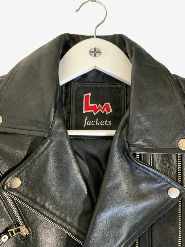 Black leather biker jacket hanging on a white wooden hanger with a small flag emblem. The inner collar label shows the brand 'LW Jackets' in red and white.