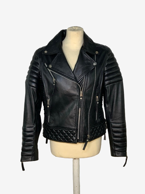 A black leather motorcycle jacket with quilted stitching on the lower front, displayed on a cream-colored mannequin torso against a plain white background.