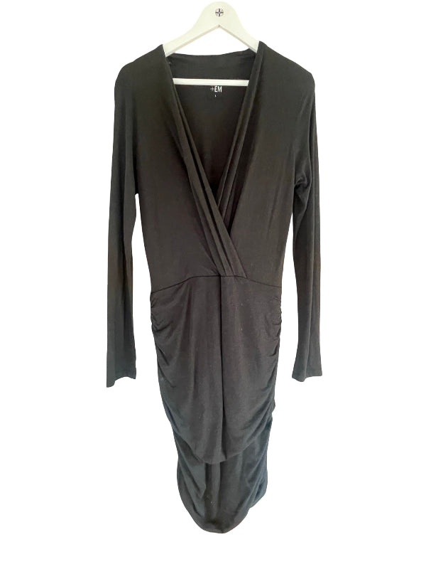 A black long-sleeve wrap dress with a draped crossover V-neckline and ruched skirt detail, hanging on a white hanger against a white background.