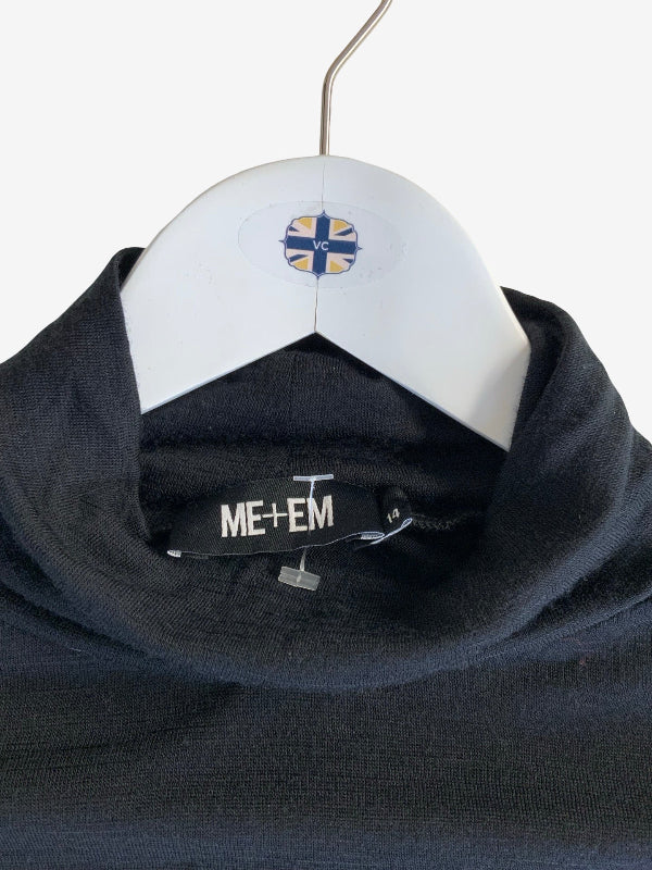 A close-up of a black knit cowl-neck sweater hanging on a white hanger with a circular ME+EM logo. The brand name 'ME+EM' is visible on the inner neck label.