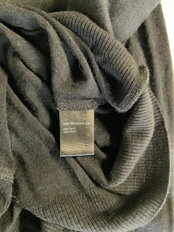 Close-up of a black jumper label ribbed knit garment with a sewn-in paper label reading www.meandem.com, 100% wool, and size 14.