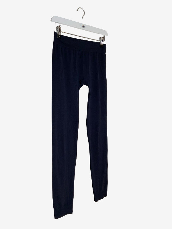 A pair of dark navy blue leggings hanging from a white plastic hanger against a light gray background.