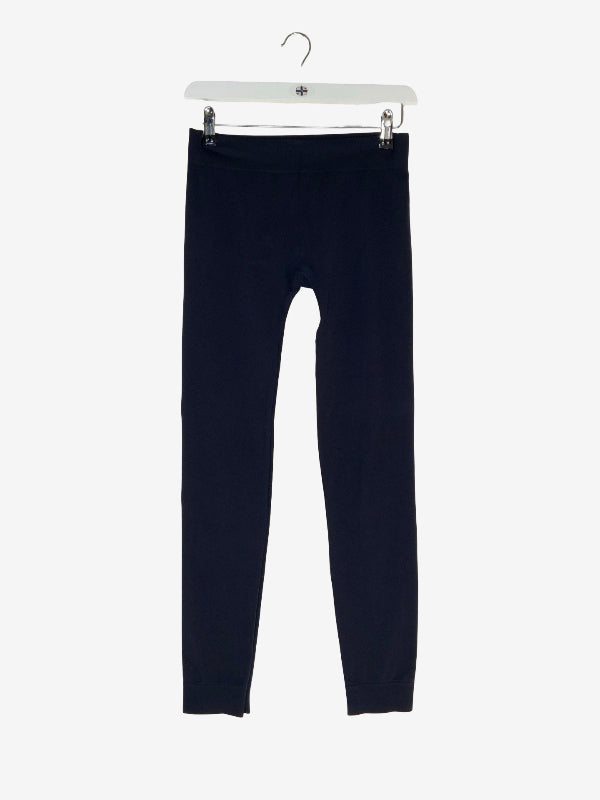 A pair of dark navy blue leggings hanging from a white plastic hanger against a light gray background.