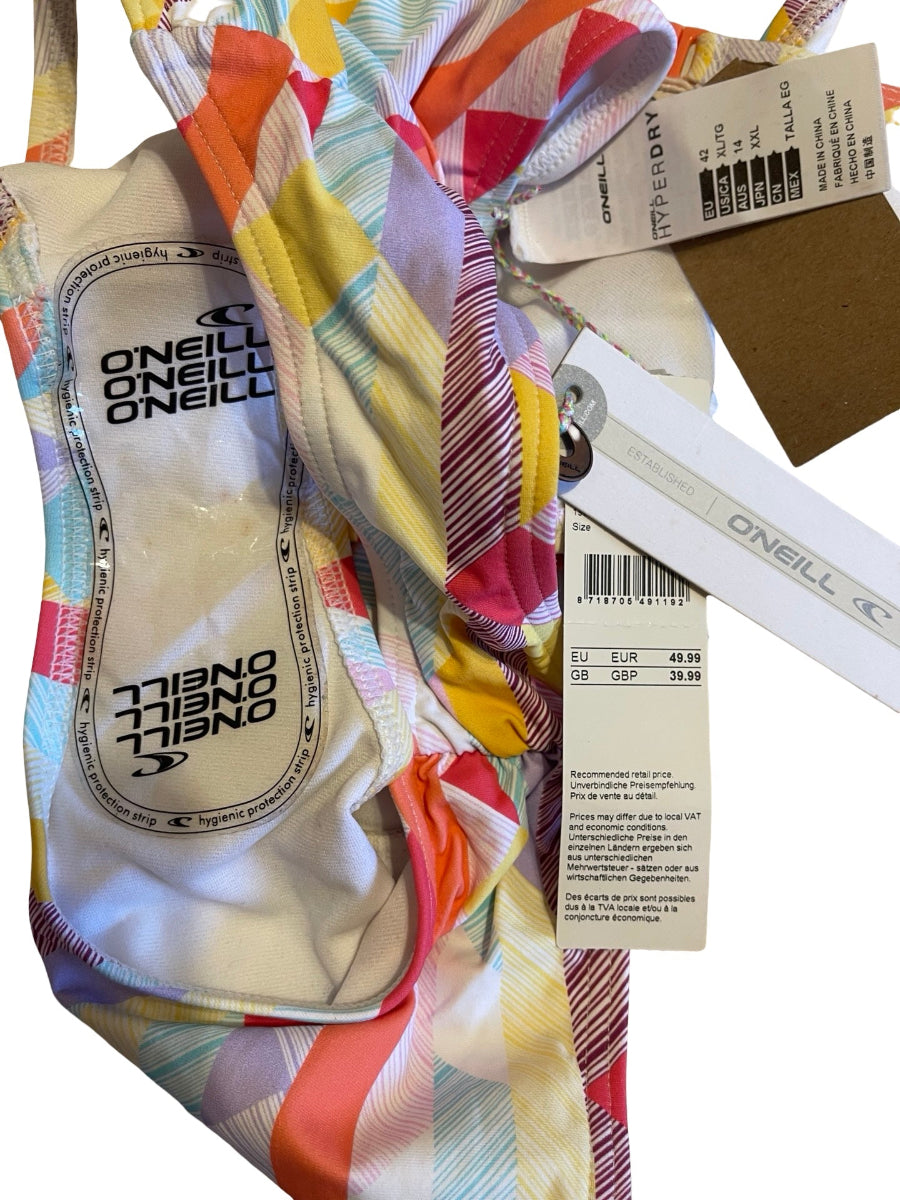 A close-up of a Oneill bikini bottom showing the printed inner label, price tag, and hanging tags over a multicolor pastel striped fabric.