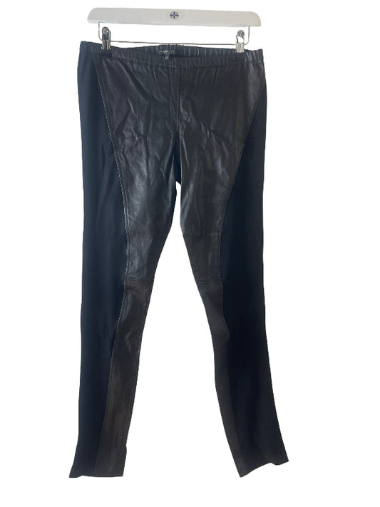 Black leather pants with contrasting black side panels, hanging on a white hanger against a white background.