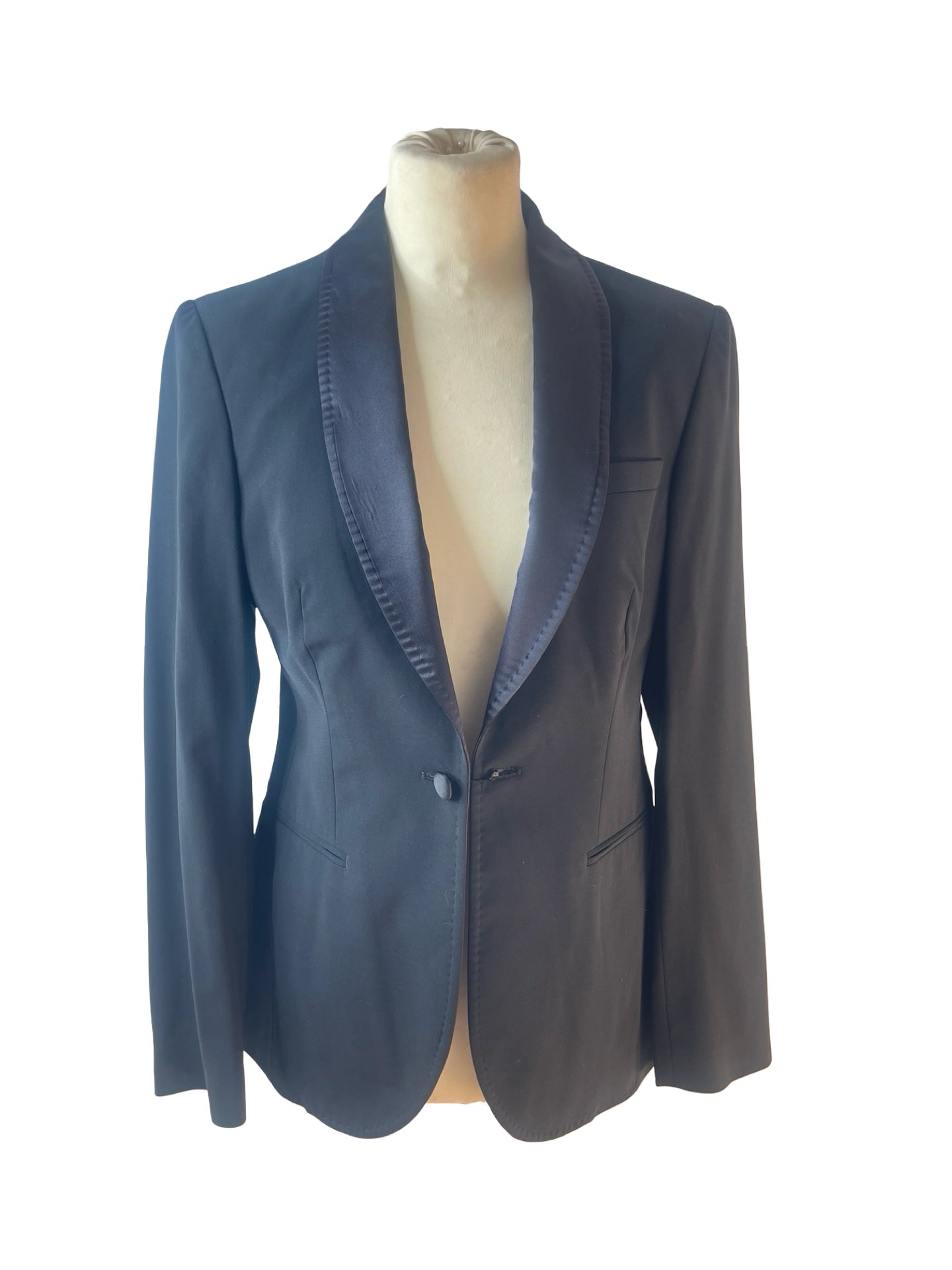 A black blazer with satin shawl lapels, displayed on a beige mannequin torso against a plain white background.