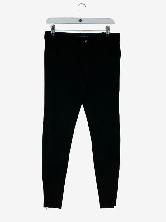 Black slim-fit jodphurs hanging from a white plastic hanger against a light gray background.