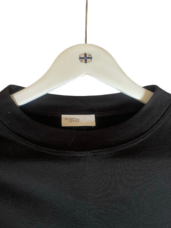 A close-up of a black crewneck sweatshirt hanging on a white wooden hanger with a small Union Jack logo, against a plain white background.