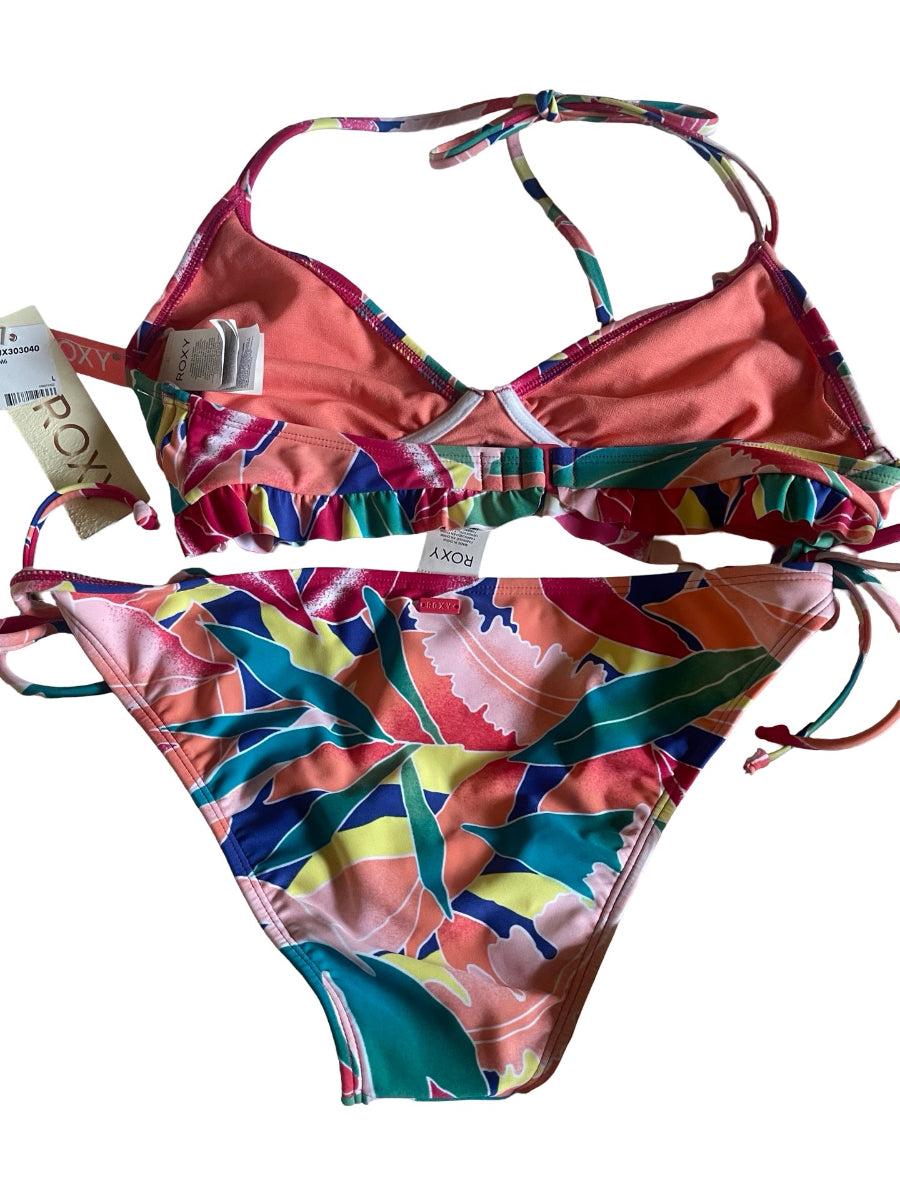 A two-piece bikini set from Axos, featuring a coral pink triangle top with multicolor ruffle trim and a matching multicolor tropical leaf print bikini bottom, shown with retail tags on a white background.