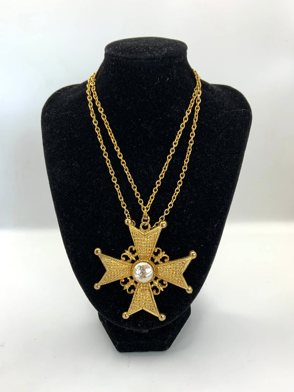 A gold-tone double-strand necklace with a Maltese cross pendant featuring a central pearl, displayed on a black velvet jewelry bust against a white background.