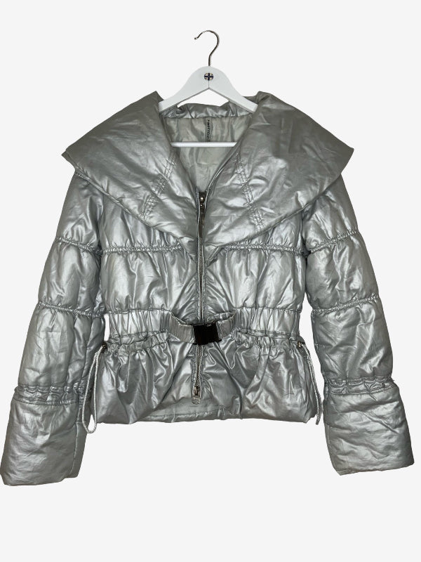 A metallic silver puffer jacket with a wide collar, front zipper, and drawstring waist, hanging on a white hanger against a light gray background.