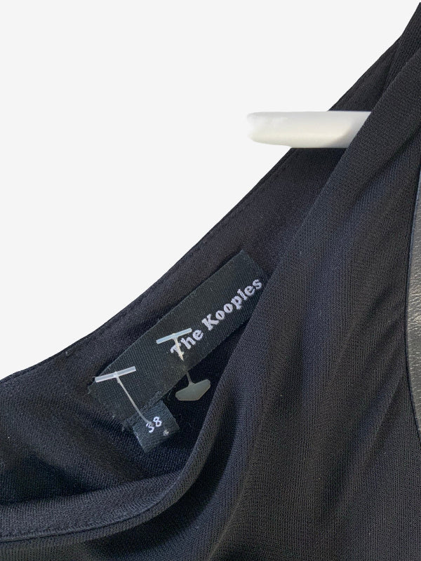 Close-up of a black garment with a visible fabric label reading 'The Kooples' and size 38, hanging against a plain white background.