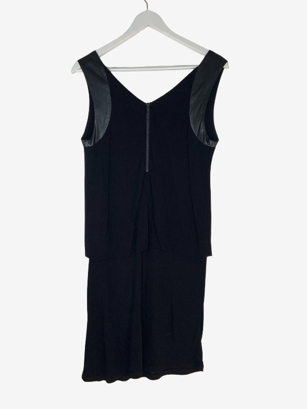 A sleeveless black dress with a V-neckline and a subtle sheen on the shoulder panels, hanging on a white hanger against a light gray background.