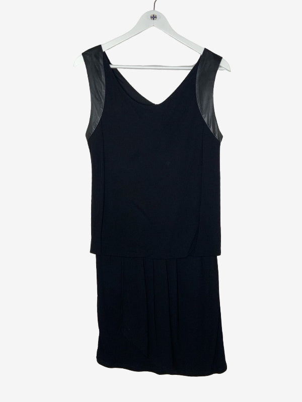 A black sleeveless V-neck dress with sheer black mesh shoulder panels, hanging on a white plastic hanger against a light gray background.