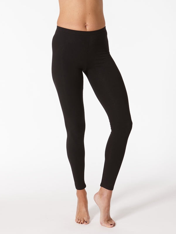 A model wearing black leggings, standing on tiptoe to show the fit and sleeveless top to expose the midriff area.