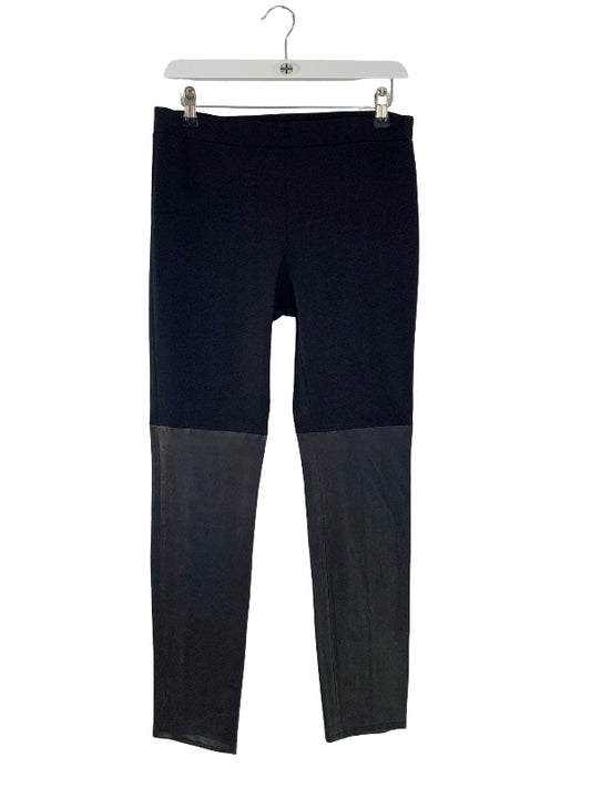 Black and black leather color-blocked pants hanging on a white plastic hanger against a white background.