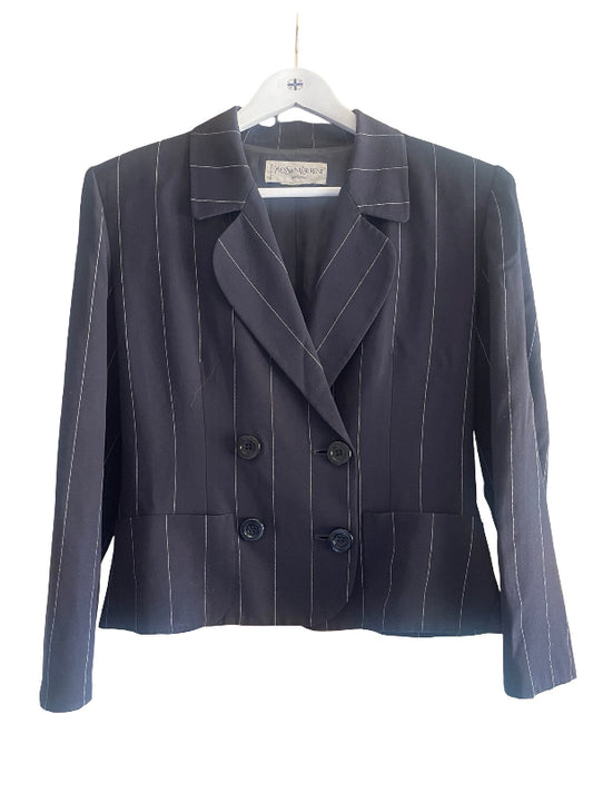 A dark navy blue double-breasted pinstripe blazer with white vertical stripes, hanging on a white hanger against a plain white background.