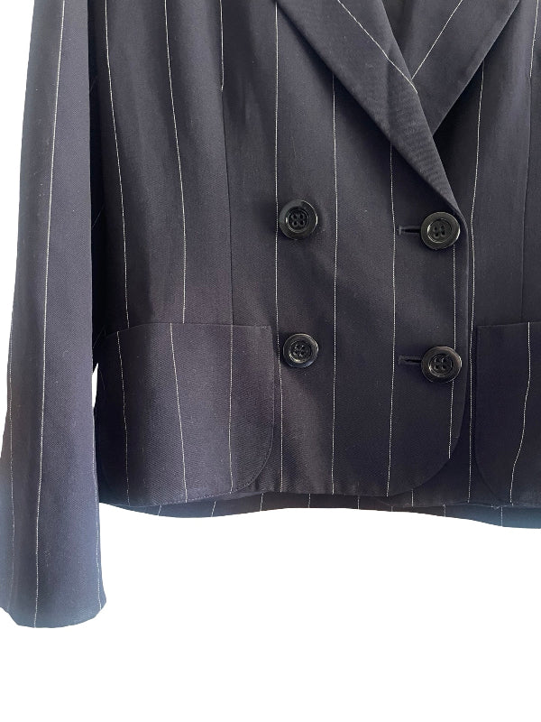 A close-up of a dark gray double-breasted pinstripe blazer with black buttons, showing the lapels, front closure, and side pockets against a white background.