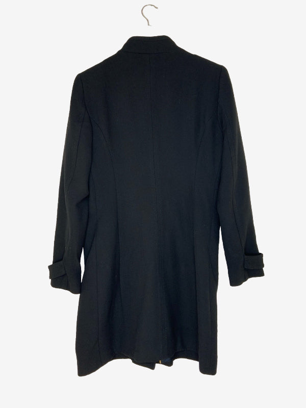 A black long-sleeve coat or tunic-style jacket hanging on a metal hanger against a plain light background, shown from the back.