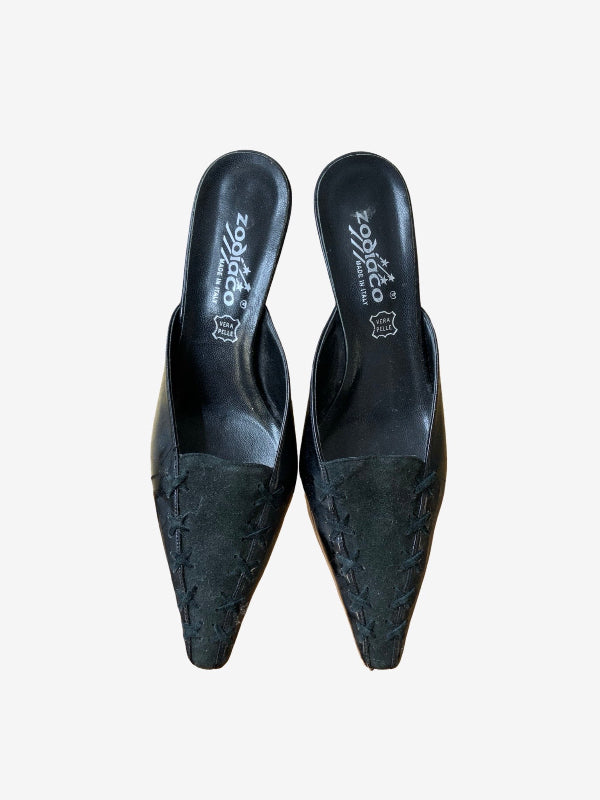 A pair of black pointed-toe mule heels with textured woven detailing on the toe, shown from a top-down view on a light gray background. The brand name 'zodiaco' is visible on the insole.