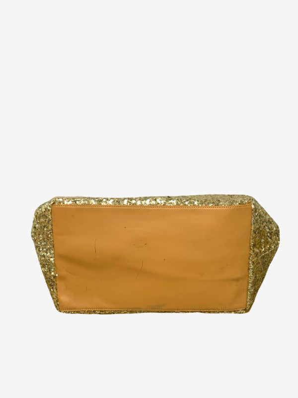 A rectangular base of bag with a smooth tan center panel and glittery gold sequined edges, shown against a plain light gray background