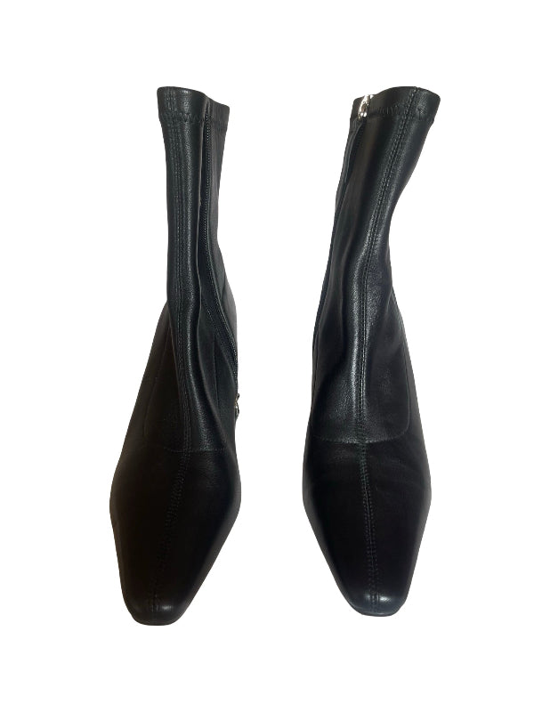 A pair of black leather ankle boots with pointed toes and side zippers, shown from the side against a plain white background.