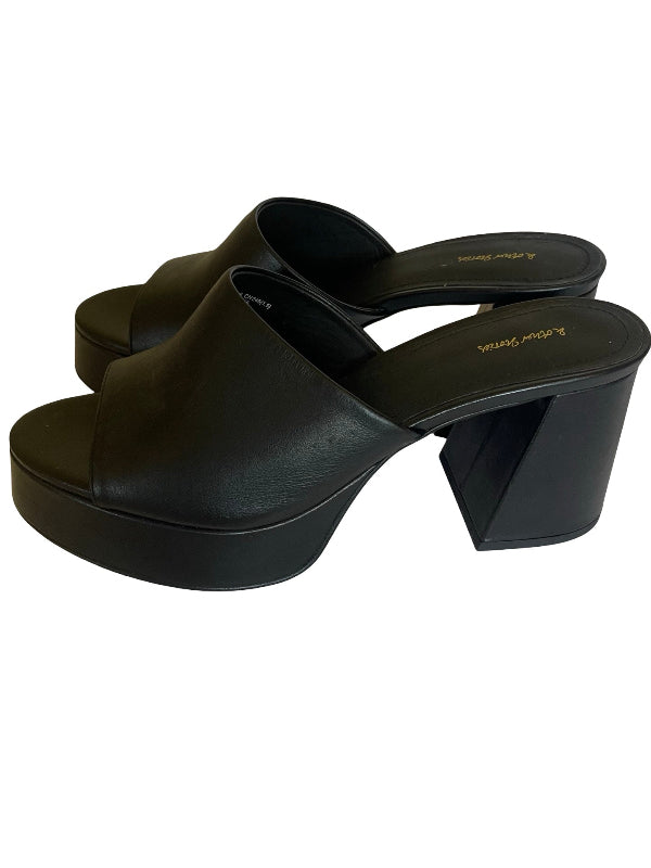 A pair of black leather platform mule sandals with a chunky block heel, shown from a side profile view on a white background.