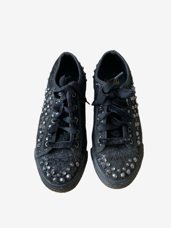 A pair of black low-top lace-up sneakers embellished with silver rhinestones around the eyelets and toe caps, shown from a top-down view on a light gray background.