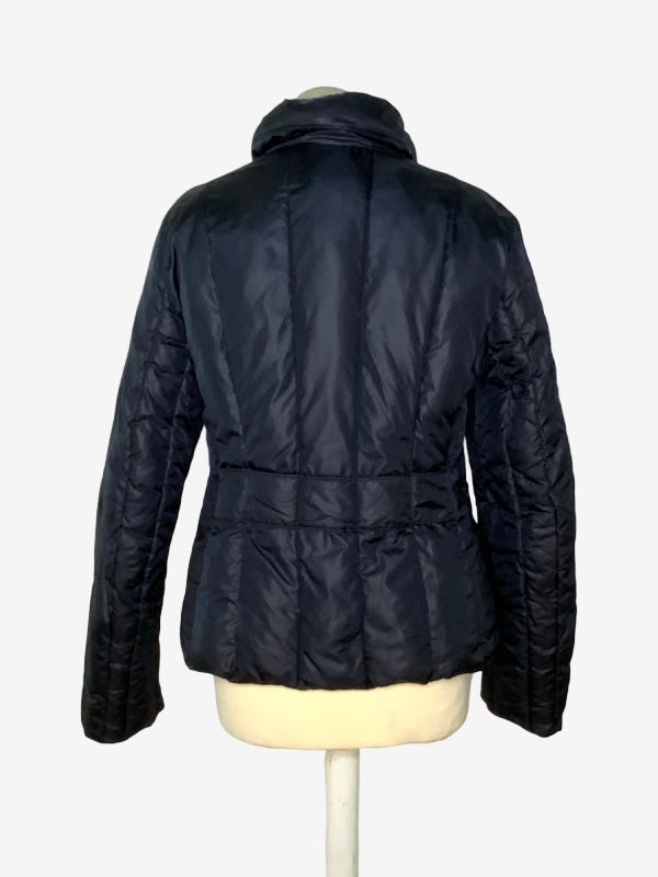 A black quilted puffer jacket shown from the back on a cream-colored mannequin torso against a light gray background.