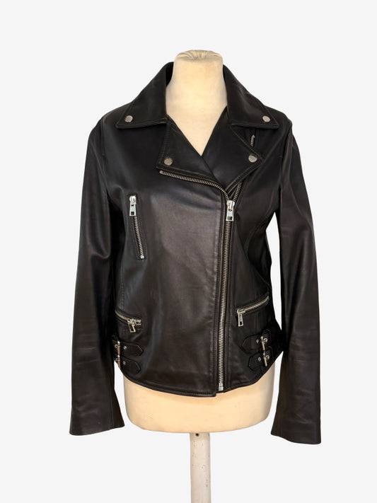 A black leather moto jacket with silver zippers and snap details, displayed on a beige mannequin torso against a light gray background.