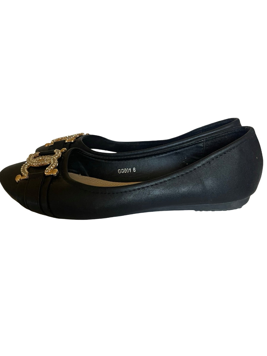 A pair black leather ballet flat shoe with a decorative gold-tone horse buckle ornament on the toe, shown against a plain white background.