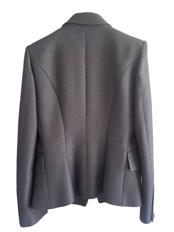 A black Balmain blazer shown from the back, featuring a structured collar, a central seam, and welt pockets on the lower back, photographed against a plain white background.