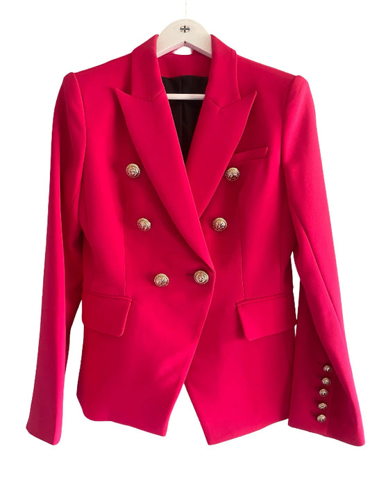 A bright raspberry double-breasted blazer with gold-tone buttons, hanging on a white hanger against a plain white background.