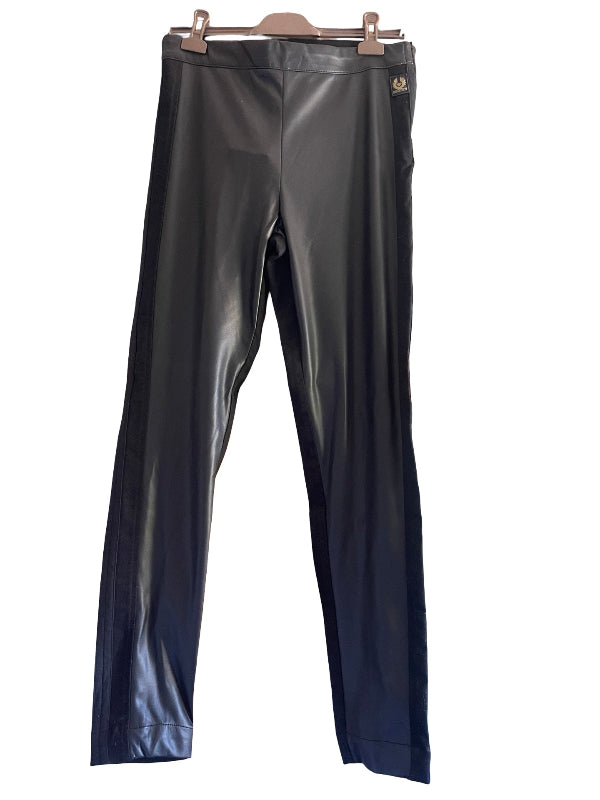 Black faux leather pants hanging on a wooden hanger against a white background.