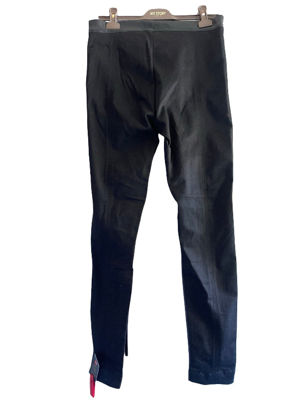 Black slim-fit pants hanging on a wooden hanger against a white background.