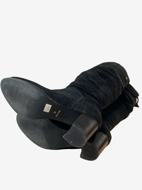 A pair of black suede knee-high boots shown from the side and sole, on a plain white background.