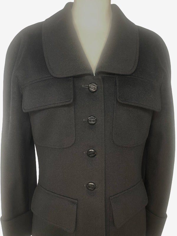 A black cashmere wool coat with a wide collar, button-front closure, and flap pockets, displayed on a mannequin torso against a white background.