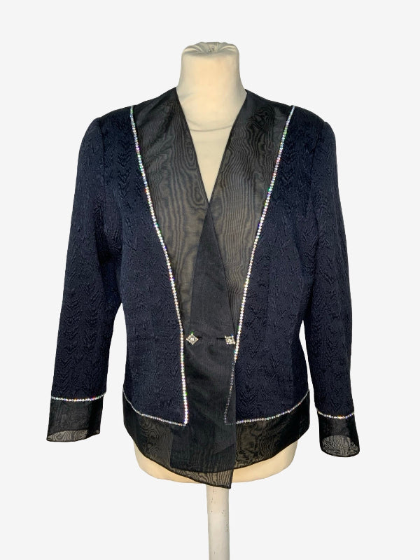 A black textured jacket with sheer black mesh trim and silver rhinestone piping, displayed on a beige mannequin torso against a white background