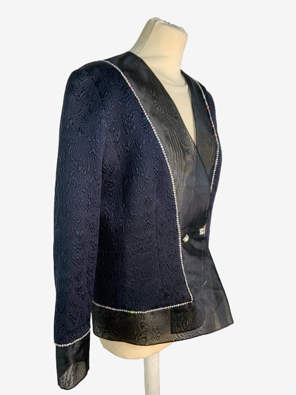 A black textured jacket with black patterned lining and silver trim, displayed on a mannequin torso against a light gray background.