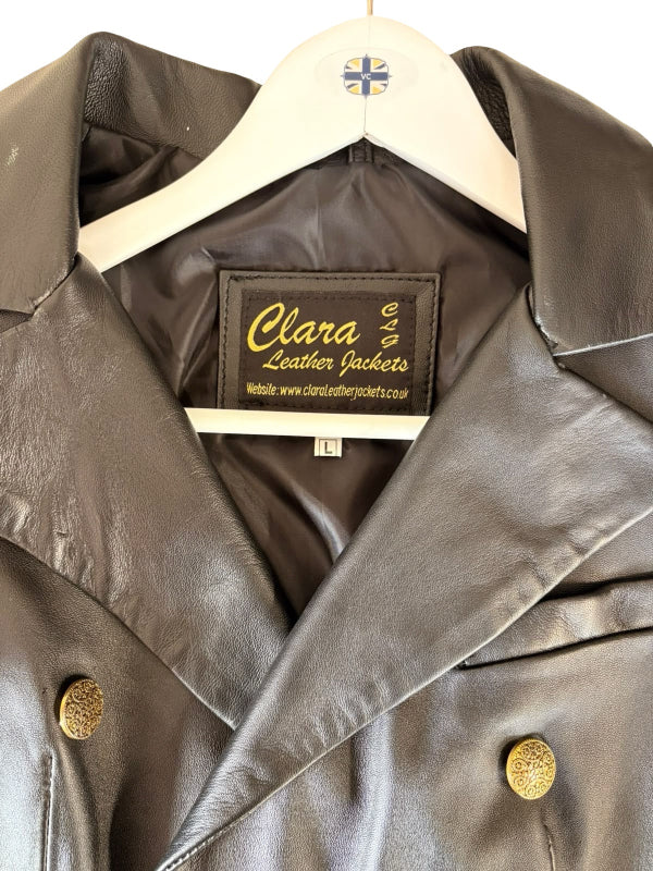 A close-up of a black leather jacket hanging on a white hanger with a small Union Jack logo. The brand label 'Clara Leather Jackets' is clearly visible inside the collar.
