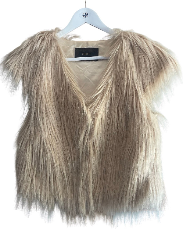 A shaggy faux fur vest in a light beige and cream color, hanging on a white hanger against a white background. A black brand label reading 'COFI' is visible at the neckline.