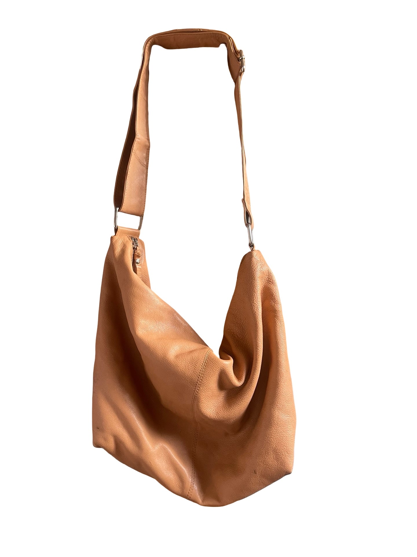 A tan leather slouchy shoulder bag with a single adjustable strap and silver-tone hardware, shown against a plain white background.