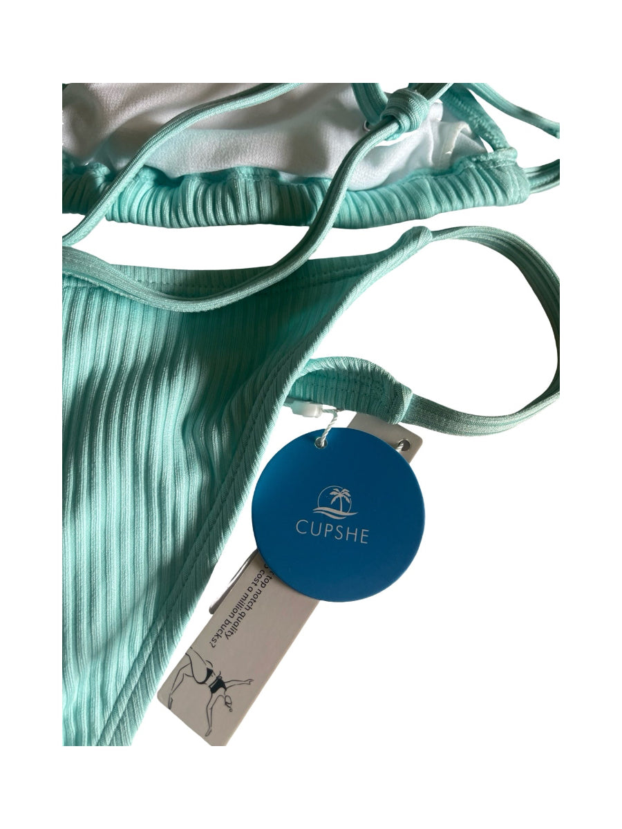 A close-up of a mint green turquoise  ribbed bikini bottom with matching tie straps and a blue circular CUPSHE brand hangtag, shown against a white background.