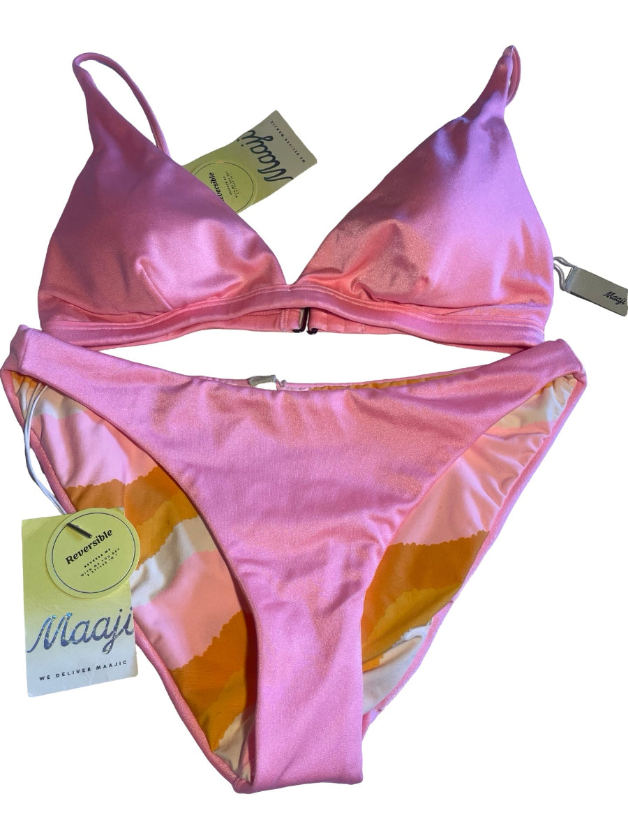 A two-piece bikini set in pink satin with a yellow and white abstract pattern lining, shown with its retail tags on a white background.