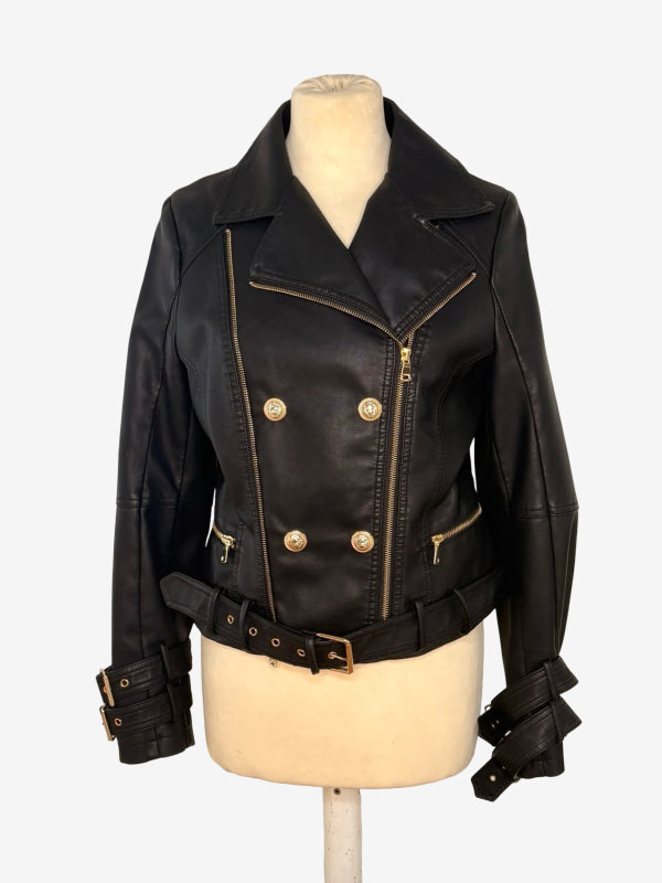 A black faux leather motorcycle jacket with gold-tone hardware, displayed on a cream-colored mannequin torso against a light gray background.