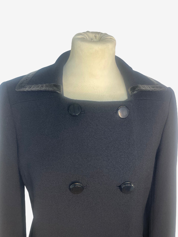 A black double-breasted coat with contrasting textured lapels, displayed on a cream-colored mannequin torso against a plain white background.