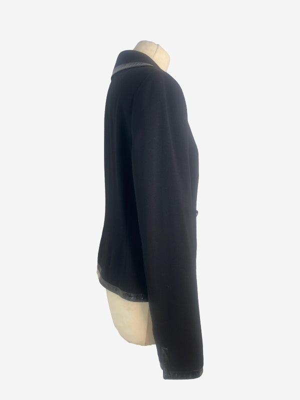 A black long-sleeve cropped jacket displayed on a cream-colored mannequin torso against a plain white background.