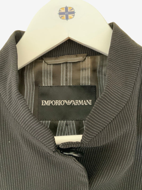 A close-up of an Emporio Armani pinstripe shirt on a white hanger, showing the black brand label with gold lettering.
