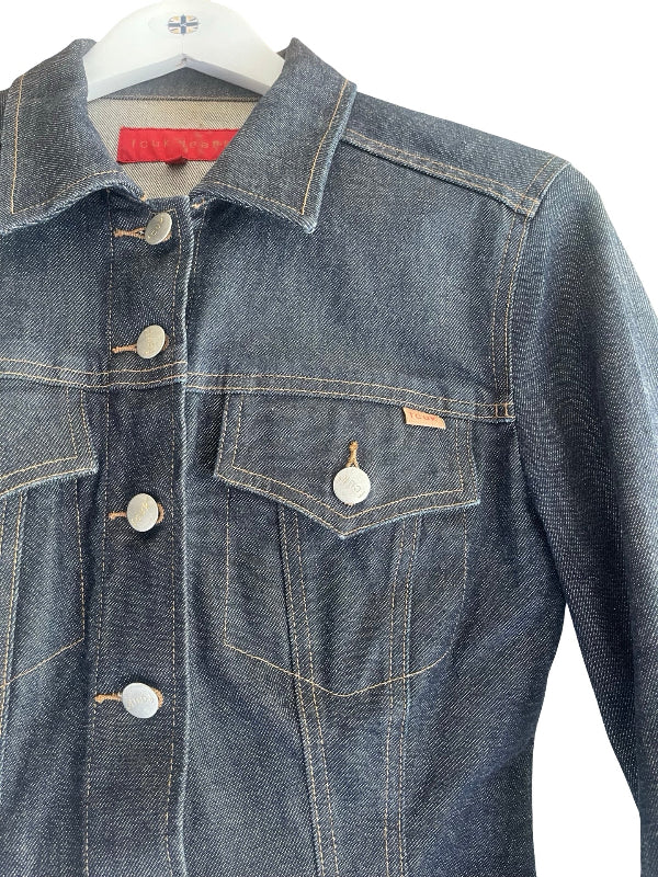 A dark blue denim jacket with silver buttons and contrast stitching, hanging on a white hanger against a white background.